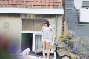Neighbor on rooftop tanning in bikinis