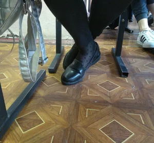 College Girl's Feet in Black Pantyhose Under Desk in Classroom