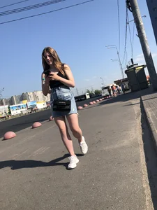 A very cute street candid girl wearing a denim fringed skirt passing by, great legs