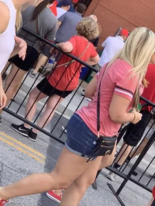 Bunch of girls in various outfits at a Cardinals baseball game