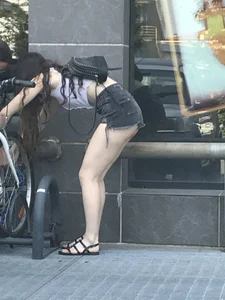 Girl in a Sandals and Black Denim Mini Shorts Bend Over for Her Bike