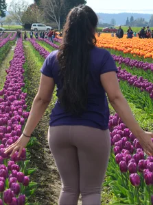 Cute babe in tight leggings taking pictures in flower fields