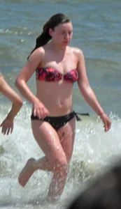 Cute beach girl in little bikini in the water