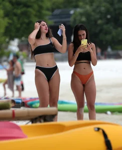 Sexy brunette friends on the beach in bikinis with great bodies