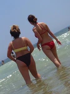 Thick girl and her skinny friend in bikinis at the beach