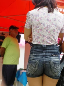 Redhead girl with her cheeks eating her denim shorts
