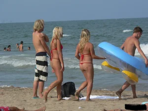Sexy mom and daughter in red thongs at the beach