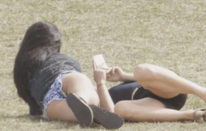 Two Hot Girls in Mini Shorts Lying on the Grass Park Creepshot