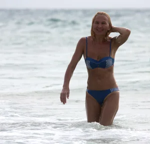 Blonde milf in a blue bikini looking sexy at the beach