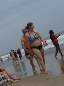Big boobed girl on the beach in blue and black bikini