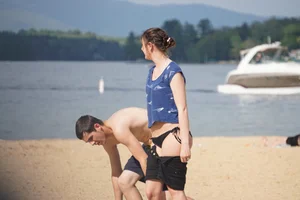 Sexy girl on the beach laying out and bending over in her bikini