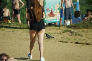 Girl with Chubby Legs in Black Shorts Walking on the Beach Photos