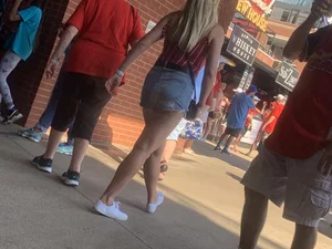 Bunch of girls in various outfits at a Cardinals baseball game