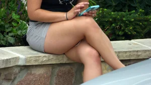 Thick brunette listening to music in shorts