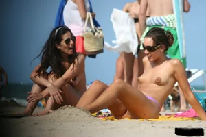 2 topless girls at the beach in thongs