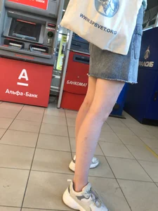 Young Candid Girl With Slim Pale Legs In a Denim Skirt Waiting in the Queue