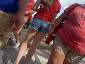 Bunch of girls in various outfits at a Cardinals baseball game