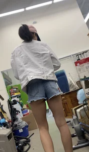 Tight bum hanging out of jean shorts in thrift shop