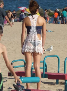 Beach teen in semi thong bikini under see through dress on the beach