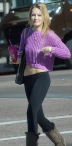 Beautiful skinny blonde in tight leggings and purple crop top showing sexy stomach