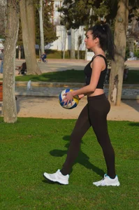 Two sexy teens playing volleyball in the park in leggings