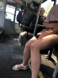 Young Girl in Sandals and Shorts in a Public Bus