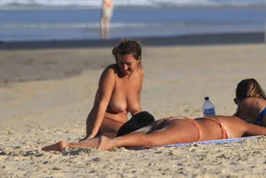 Sexy girls topless on a nude beach showing their nice tits
