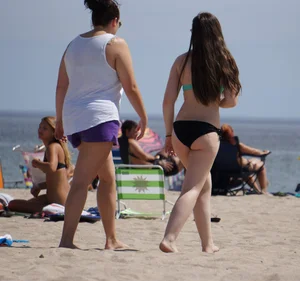 Sexy beach brunette in teal top and black bottom bikini