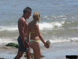 Sexy blonde on the beach in a yellow thong bikini