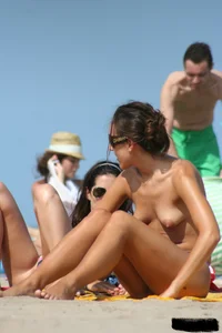 2 topless girls at the beach in thongs