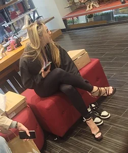 Candid hot girl trying on high heels in the store
