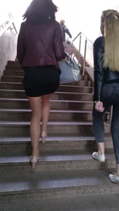 Hot girl walking up the stairs, wearing a skirt, pantyhose and high-heeled shoes