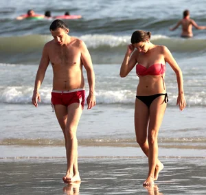 Skinny small boobed girl in a bikini on the beach with her friend