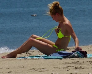 Sexy ass blonde milf on the beach in a thong with cameltoe and bending over