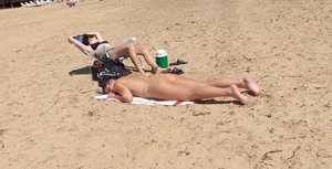 Girl laying out getting sun in a white thong bikini