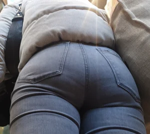 Girl with a tight ass in grey jeans going up the escalator