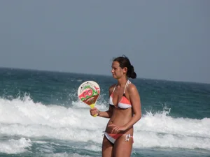 Skinny and sexy lady in a bikini playing on the beach