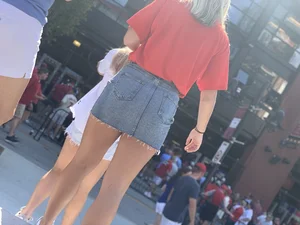 Bunch of girls in various outfits at a Cardinals baseball game