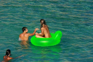 FKK Nudists playing in the water with floater