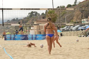 Sexy beach volleyball girl in sport bra top with pokies and blue bikini bottom
