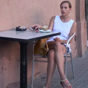 Candid chick with hot crossed legs sitting in a street cafe