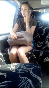 Girl in a Skirt Speaking in the Phone in a Bus