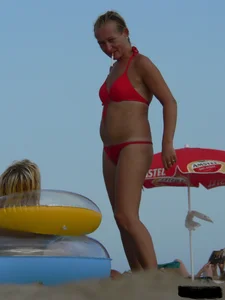 Sexy mom and daughter in red thongs at the beach