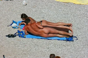 Nudist couple on the beach, girl has amazing tits and nice ass in a thong