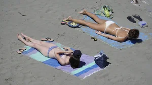 Sexy beach girl laying out in white bikini with nice body