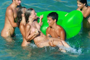 FKK Nudists playing in the water with floater