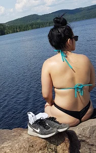 Thick brunette at the lake in a black thong bikini