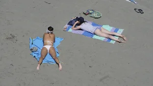 Sexy beach girl laying out in white bikini with nice body