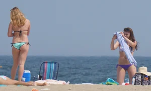 Cute girls in light blue and purple bikinis on the beach