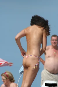 2 topless girls at the beach in thongs